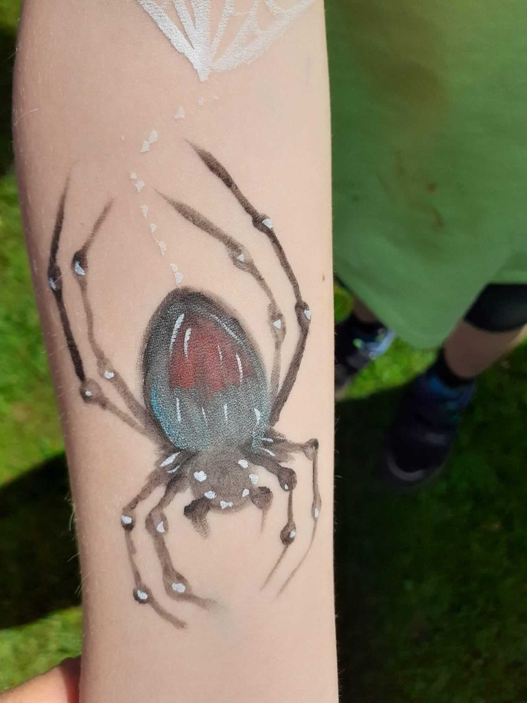 Image of a painted spider on a childs arm